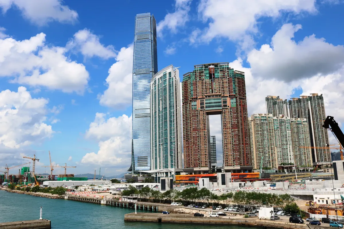 香港の港辺のスカイラインを美しく見せる、アイコン的な超高层ビルが晴朗な青空の下に立つ